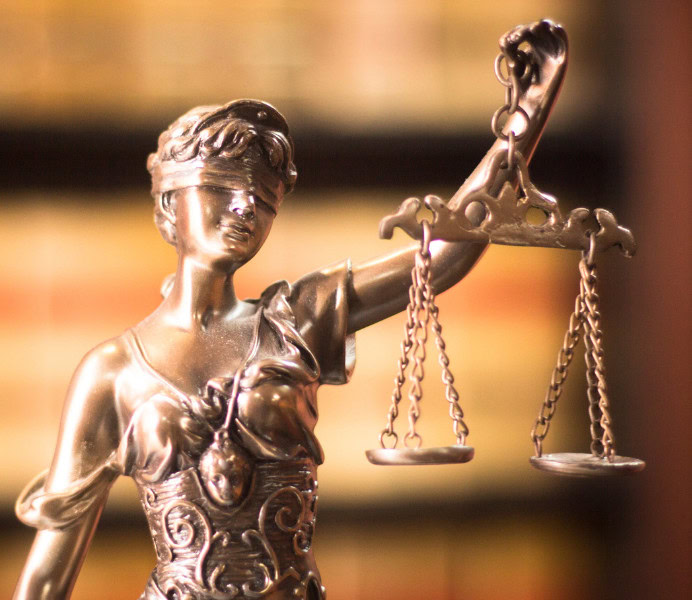 Bronze statue of Lady Justice holding scales, symbolizing fairness and the law.